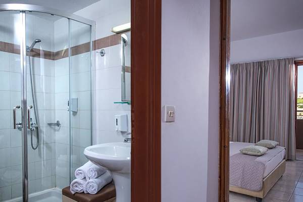 Ein Badezimmer im Blue Bay Resort Hotel mit Dusche, Waschbecken und Bett.