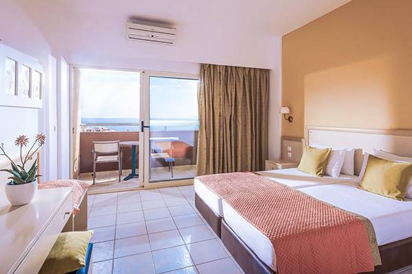 Hotelzimmer im Blue Bay Resort mit Meerblick, Doppelbett, Balkon und Klimaanlage.