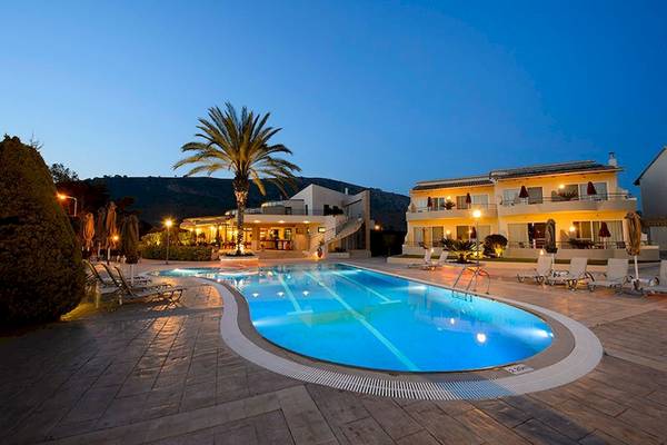 Außenpool des Verde Al Mare Hotels bei Nacht mit Loungestühlen und Gebäude im Hintergrund.