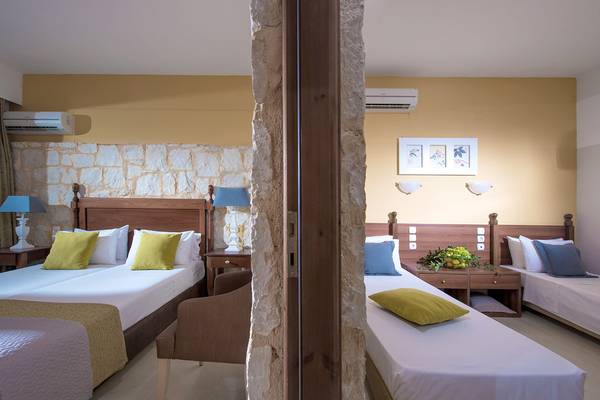 Ein luxuriöses Schlafzimmer im Blue Bay Resort mit zwei Betten, Kissen, Lampen und einem Steinwanddesign.