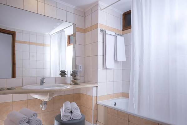 Ein Badezimmer im Blue Bay Resort mit Badewanne, Dusche, Spiegel und Handtüchern.