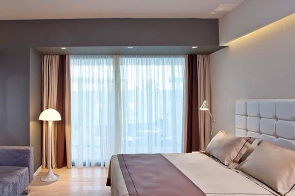 Hotelzimmer des Aqua Blu Boutique Hotel & Spa mit Fernseher, Lampe, Bett und Couch