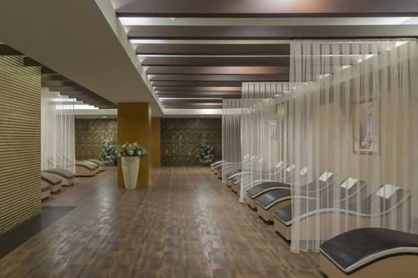Spa-Bereich des Royal Alhambra Palace Hotels mit Lounge-Liegen, goldenen Wänden und weißen Vorhängen.