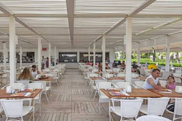 Gäste sitzen in einem überdachten Außenrestaurant des Royal Alhambra Palace Hotels.