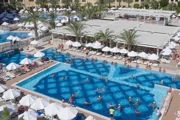 Luftaufnahme des Swimmingpool-Bereichs des Royal Alhambra Palace Hotels mit vielen Gästen und Sonnenschirmen.
