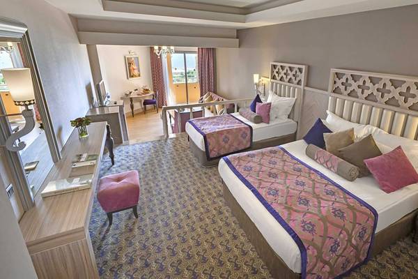 Innenansicht einer Suite im Royal Alhambra Palace Hotel mit zwei Betten, Dekor und Möbeln.