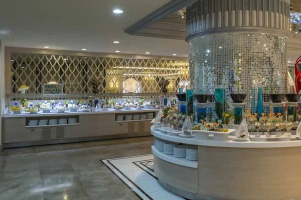Buffetbereich im Royal Alhambra Palace Hotel mit verschiedenen Gerichten und einer zentralen Säule.