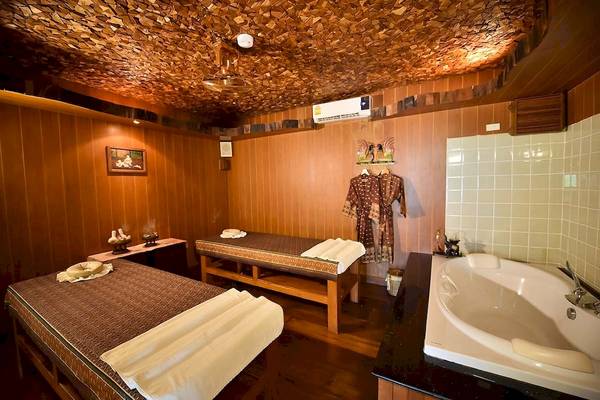 Behandlungsraum im Santhiya Koh Phangan Resort & Spa mit zwei Massagebetten und Badewanne.