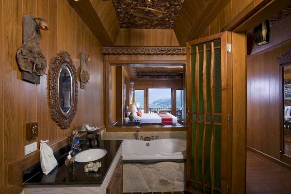 Badezimmer im Santhiya Koh Phangan Resort & Spa mit Badewanne und Ausblick auf das Zimmer.
