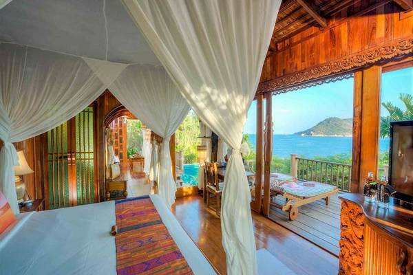 Schlafzimmer im Santhiya Koh Phangan Resort & Spa mit Blick auf das Meer und einen Pool.