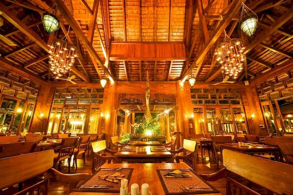 Innenbereich des Santhiya Koh Phangan Resort & Spa mit Restaurantbereich und Holzmöbeln.
