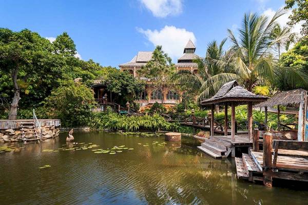 Außenansicht des Santhiya Koh Phangan Resort & Spa mit Gebäuden und Teich.