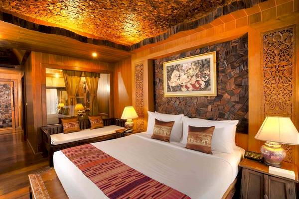 Schlafzimmer im Santhiya Koh Phangan Resort & Spa mit Holzelementen und Dekor.