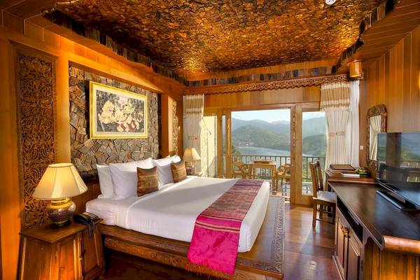 Innenansicht des Schlafzimmers im Santhiya Koh Phangan Resort & Spa mit Blick auf die Berge.