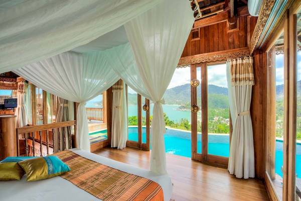 Bett mit Blick auf den Pool im Santhiya Koh Phangan Resort & Spa