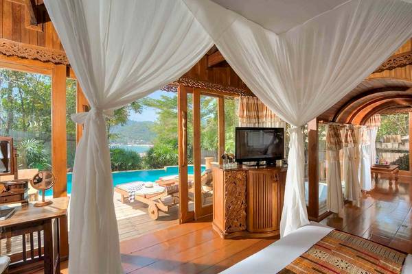 Innenansicht einer Suite im Santhiya Koh Phangan Resort mit Blick auf einen Pool und einer Terrasse.