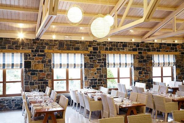 Innenansicht des Restaurants im Ostria Resort & Spa mit Steinwänden und runden Lampen.