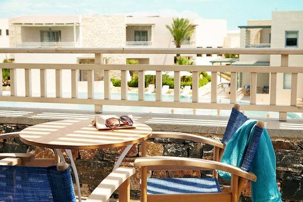 Terrasse des Ostria Resort & Spa mit Stühlen und Tisch und Blick auf den Pool