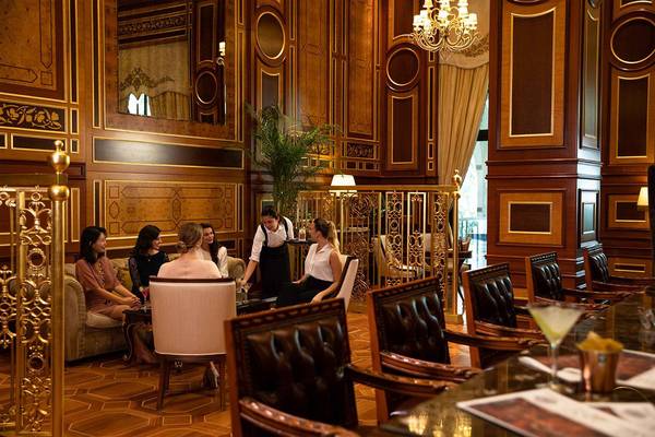 Loungebereich im Jumeirah Zabeel Saray Hotel mit einer Gruppe von Frauen und einer Bedienung.