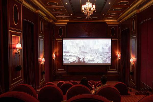 Innenraum des Kinosaals im Jumeirah Zabeel Saray Hotel mit roten Stühlen und einer großen Leinwand.