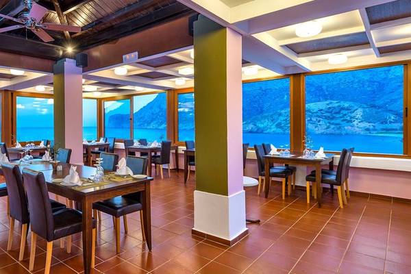 Innenansicht eines Restaurants im Fodele Beach & Water Park Holiday Resort mit Blick auf das Meer.