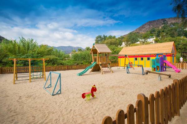 Spielplatz des Fodele Beach & Water Park Holiday Resort mit bunten Spielhäusern und Sandkasten.
