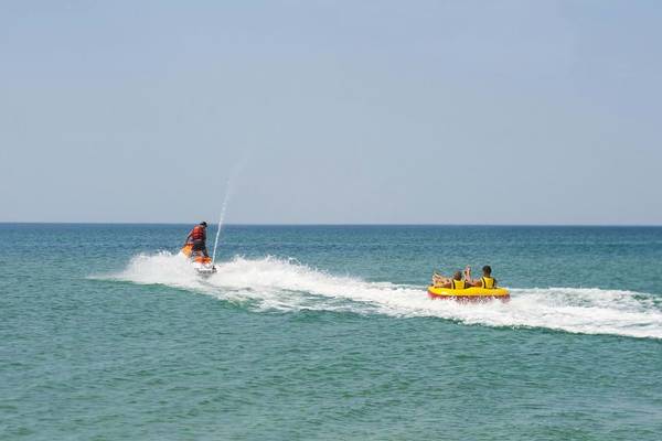 Wassersport am Fodele Beach & Water Park Holiday Resort mit Personen auf Jetski und Schlauchboot.