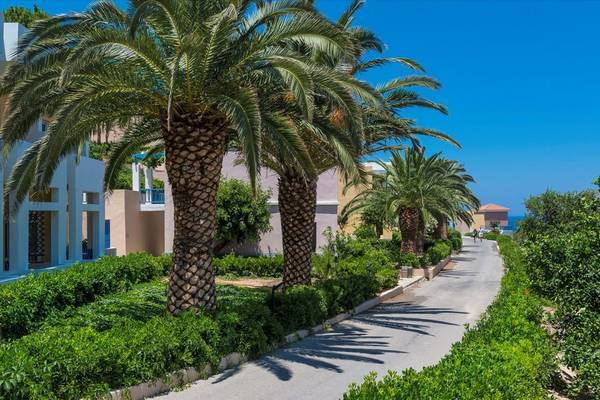 Außenansicht des Fodele Beach & Water Park Holiday Resorts mit Palmen und Gebäuden