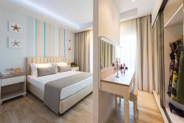 Doppelzimmer im Fodele Beach & Water Park Holiday Resort mit Bett, Nachttischen und Kleiderschrank.
