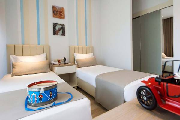 Zweibettzimmer im Fodele Beach & Water Park Holiday Resort mit Spielzeugauto und Trommel auf den Betten.