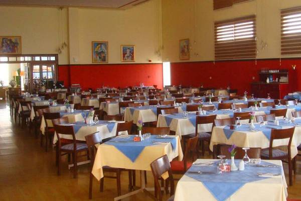 Restaurant des Aktea Beach Village Hotels mit vielen blau-weiß gedeckten Tischen und Stühlen.