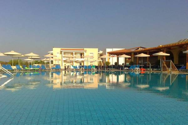 Ein großer Swimmingpool mit blauen Liegestühlen und Sonnenschirmen im Aktea Beach Village.