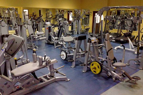 Fitnessstudio im Aktea Beach Village Hotel mit vielen Trainingsgeräten und gelben Wänden