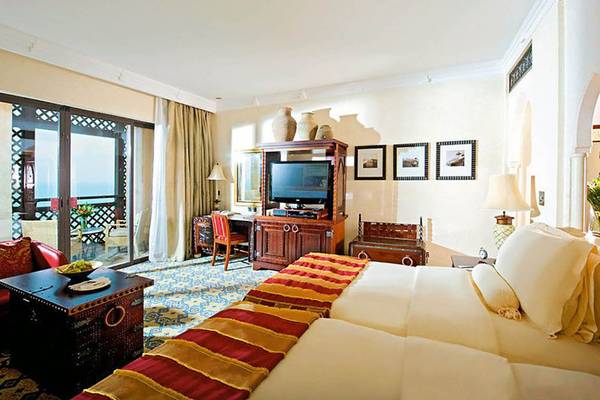 Suite Zimmer im Jumeirah Dar Al Masyaf Hotel mit Fernseher, Schreibtisch und Balkon.