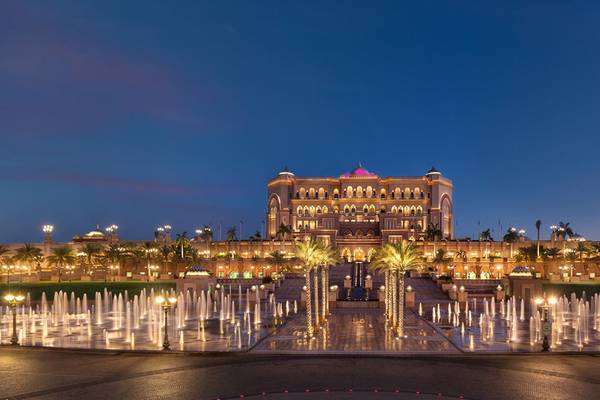 Abendansicht des Emirates Palace Mandarin Oriental Hotels mit Brunnenanlage und Beleuchtung.