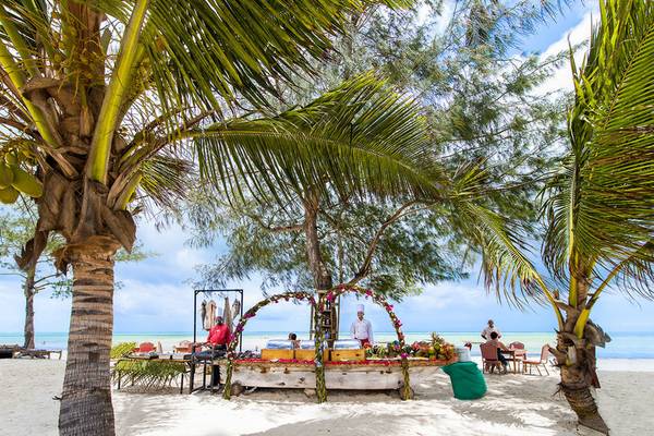 Buffet-Tisch von Bahari Zanzibar auf dem Strand mit Palmen und Gästen.