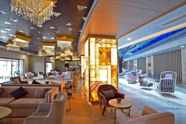Innenansicht der Lobby des Royal Wings Hotels mit eleganten Möbeln und Kronleuchtern.