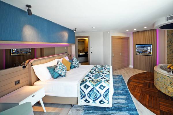 Schlafzimmer im Royal Wings Hotel mit Doppelbett, Whirlpool und modernem Interieur.