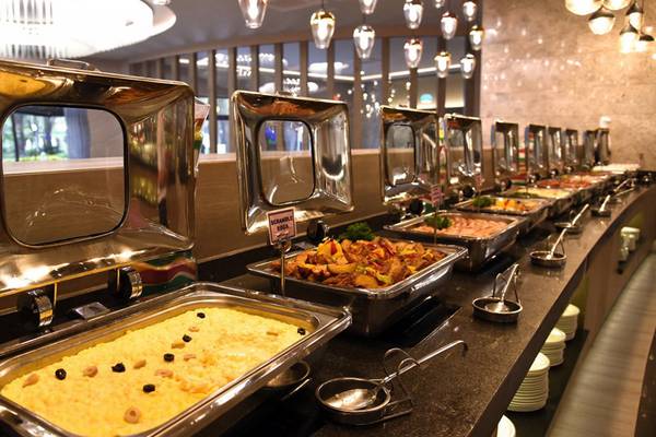 Buffet-Tisch im Royal Wings Hotel mit verschiedenen Gerichten in silbernen Aufwärmschalen.