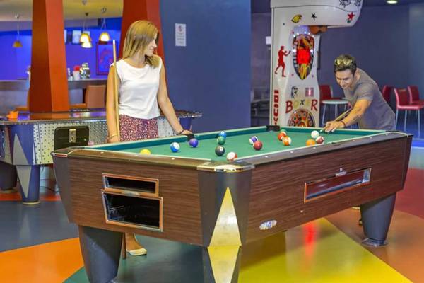 Ein Mann und eine Frau spielen Billard in der Lobby des Royal Wings Hotels.