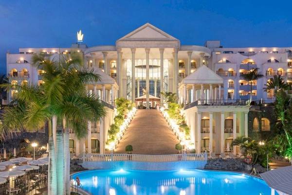 Die Fassade des Princess Inspire Tenerife Hotels mit Pool und Palmen in der Nacht