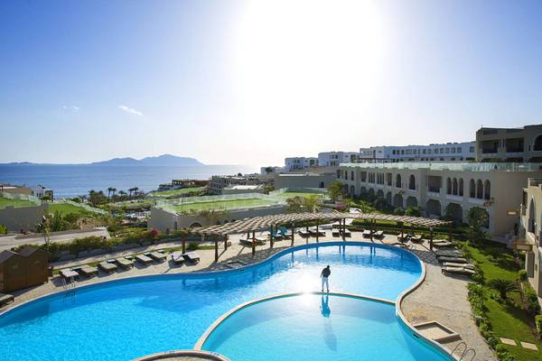 Außenpool im Sunrise Arabian Beach Resort mit Person und Meer im Hintergrund