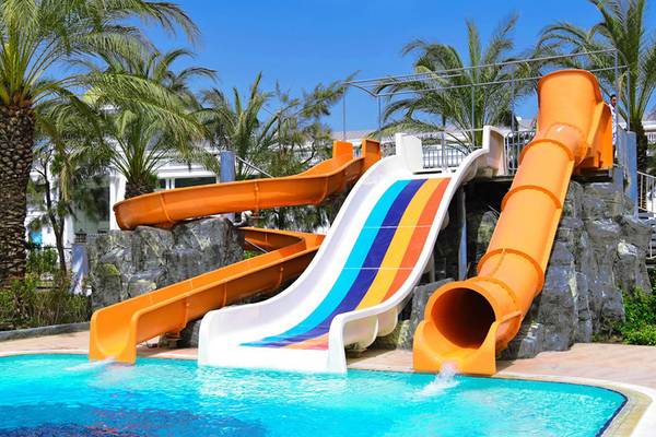 Wasserrutschen im Freien neben einem Schwimmbad im Royal Wings Hotel.