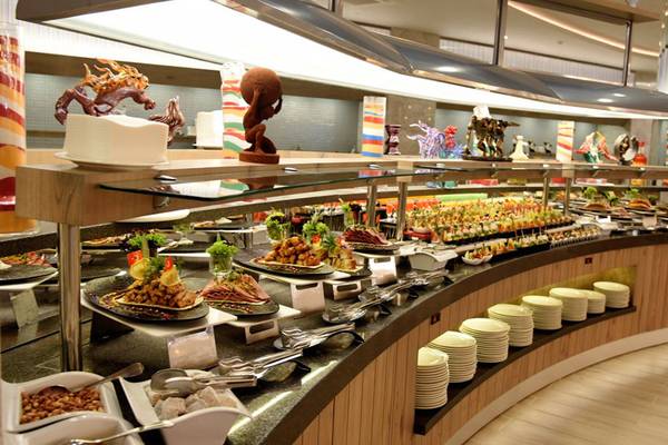 Buffet-Tisch im Royal Wings Hotel mit verschiedenen Speisen auf einem Glasdisplay.