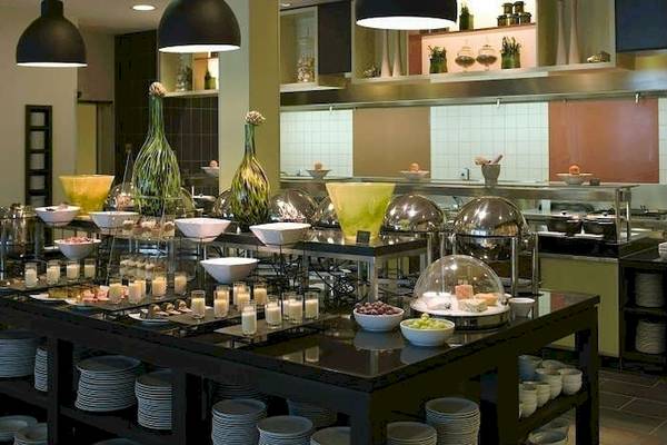 Buffet-Tisch im Mövenpick Amsterdam City Centre Hotel mit verschiedenen Speisen und Dekoration.