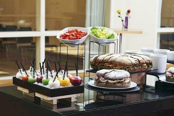 Buffet-Tisch im Mövenpick Hotel Amsterdam City Centre mit verschiedenen Gerichten, Salaten und Getränken.