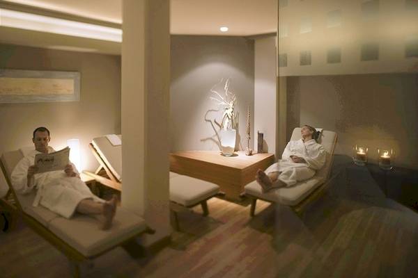 Ein Mann liest eine Zeitung auf einem Liegestuhl im Spa des Mövenpick Amsterdam City Centre