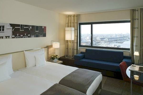 Doppelbettzimmer im Mövenpick Amsterdam City Centre Hotel mit Stadtblick
