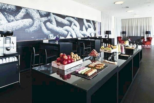 Buffettisch im Mövenpick Amsterdam City Centre mit Obst, Gebäck und Getränken.