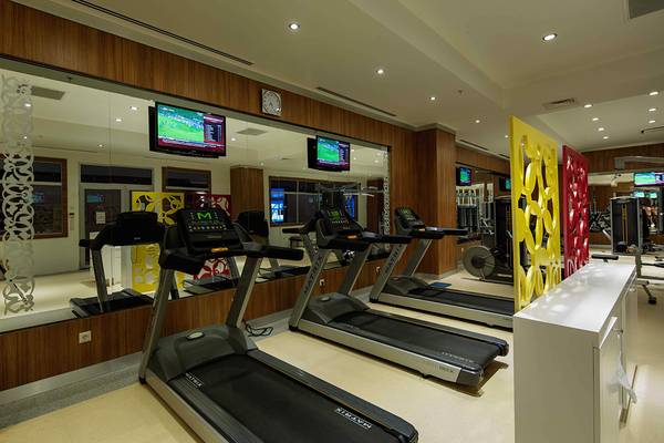 Fitness-Center im Crystal Sunset Luxury Resort & Spa mit drei Laufbändern und Spiegeln.